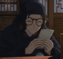 a man wearing glasses and a hat is holding a piece of paper