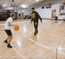 a man wearing a hoodie with the number 23 on it plays basketball