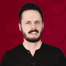 a man with a beard and mustache is making a face and the word yeah is above him