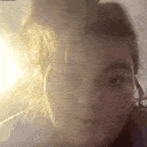 a close up of a person 's face with the sun shining through the window behind them .