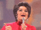 a woman in a red dress is holding a microphone