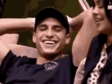 a man and woman are sitting next to each other on a couch and smiling .