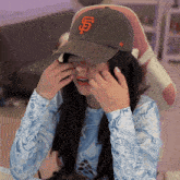 a woman wearing a san francisco giants hat