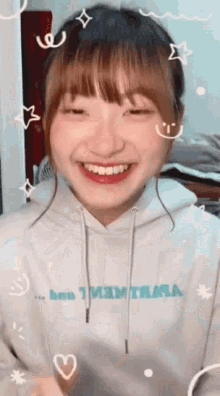 a girl wearing a white hoodie that says ' i 'm thirsty ' on it smiles