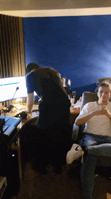 a man in a white nike shoe sits next to another man in a chair