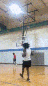 a person playing basketball on a court with a basketball hoop in the background