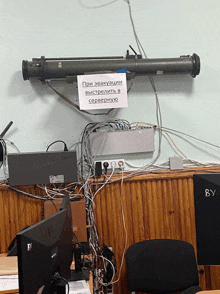 a sign that says " при эвакуации " hangs above a bunch of wires