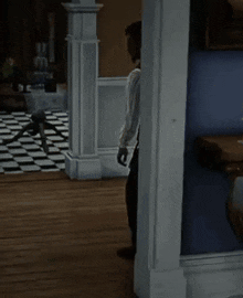 a man in a vest and tie is standing in a room with a checkered floor