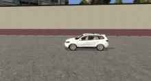 a white car is parked in front of a large wall