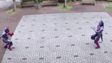 two superheros are fighting each other on a brick sidewalk