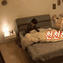 a person laying on a bed with korean writing on the wall