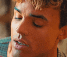 a close up of a man 's face with his eyes closed and his mouth open