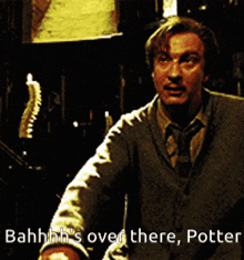 a man in a sweater and tie says bahhh 's over there potter in a dark room