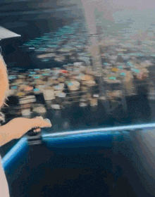 a woman stands in front of a large screen with a reflection of a city
