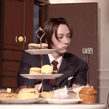 a man in a suit and tie is sitting at a table with a tray of food on it .