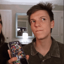 a man is holding a phone with a case that says ' spiderman ' on it