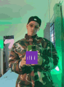 a man in a camo jacket is holding a purple box with the number 7 in the background