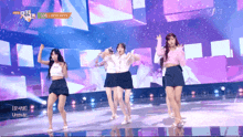 a group of girls are dancing on a stage with a kbs logo above them