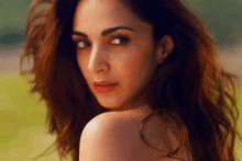 a woman with long red hair is looking over her shoulder