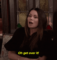 a woman is sitting on a couch and says oh get over it