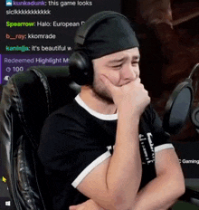 a man wearing headphones and a headband is sitting in front of a microphone and crying .