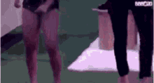 a couple of women are standing next to each other on a green field .