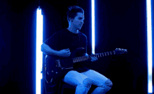 a man in a black shirt is playing a guitar that says ibanez on it