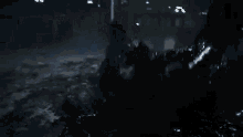 a person is crawling on the ground in a dark room in a movie .