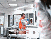 a man in an orange vest is standing in front of a box that says human blood