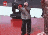 a person is standing on a red floor in front of a sign that says tpo