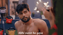 a shirtless man is talking to a woman who is holding a glass of wine and says abhi sweet ho gaya