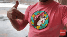 a man wearing a pink t-shirt with a squirrel and bananas on it