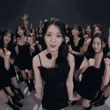 a girl in a black dress is surrounded by other girls