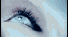 a close up of a woman 's eye with a blue background