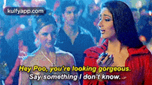 two women are standing next to each other and one of them is talking to the other .