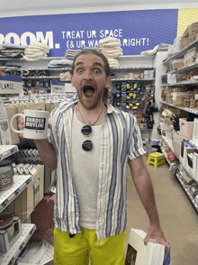 a man holds up a mug that says dunder mifflin