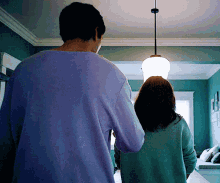 a man in a purple shirt is holding a woman 's hand