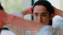a man with glasses looks at himself in the mirror
