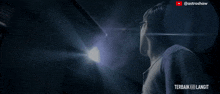 a man is standing in front of a light with the words terbaik langit on the bottom right
