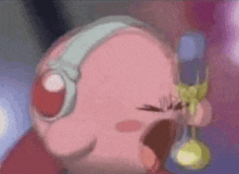 kirby is wearing headphones and holding a spoon in his mouth .