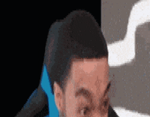 a close up of a man 's face with a black background and a blue ribbon around his neck .