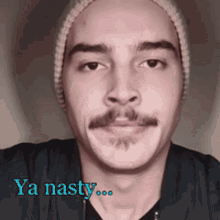 a man wearing a beanie and a black shirt with the words ya nasty