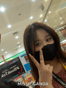 a woman wearing a black mask is giving a peace sign and has missuganda written below her