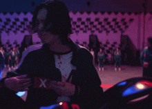 a group of people are standing in a gym with a checkered wall