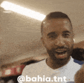 a man with a beard is smiling with the words @ bahia.tnt written below him
