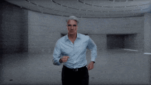 a man in a blue shirt is covering his face with his hands