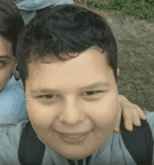 a young boy with a backpack smiles for a picture