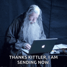 an old man with a beard is using an apple laptop