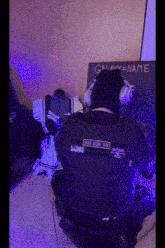a person wearing headphones is kneeling down in front of a galaxy name sign