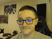 a boy wearing glasses is sitting in front of a chair that says ing